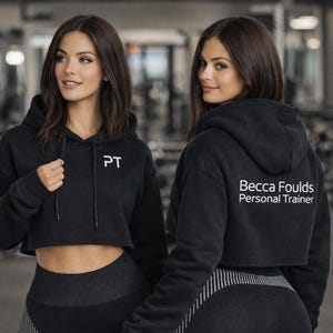 Female Model Wearing Personalised Personal Trainer Women's Cropped Hoodie in Black with White Custom Print