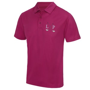 May include: A pink short-sleeved polo shirt with a white embroidered logo of crossed golf clubs and the letters "LP".