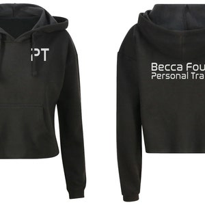 May include: Black cropped hoodie with a white "PT" logo on the front and "Becca Foulds Personal Trainer" on the back.