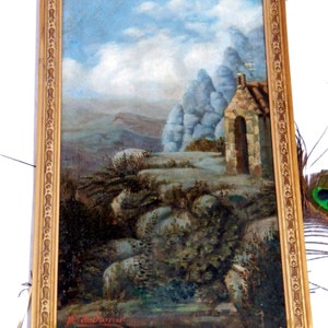 May include: A framed oil painting depicting a landscape with a small stone building in the foreground. The building has a rounded archway and a stone roof. The background features a rocky hillside with a blue sky and white clouds. The painting is signed "M. Macdonald" in the lower right corner.