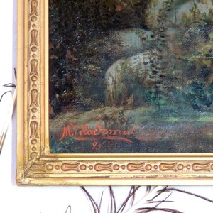 May include: A close-up of a painting in a gold frame. The painting is of a forest scene with a signature in the bottom right corner that reads "Miladoman 90".