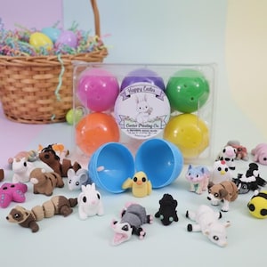 May include: An Easter-themed display featuring a wicker basket filled with colorful eggs and decorative grass. A clear plastic container holds six plastic eggs, and a variety of small animal figurines are scattered around the eggs.