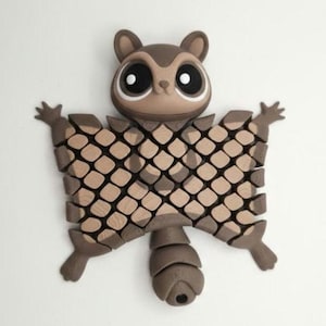 May include: A brown and tan 3D-printed sugar glider figurine. The figurine has large, round eyes, small ears, and a segmented body with a grid-like pattern. The sugar glider's arms and legs are outstretched, and it has a segmented tail.