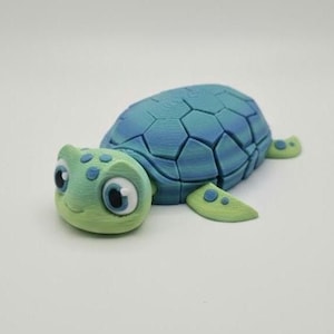 May include: A 3D-printed turtle figurine in shades of blue and green. The turtle's shell is a mosaic of blue, while its head and flippers are green. The turtle has large, expressive eyes.