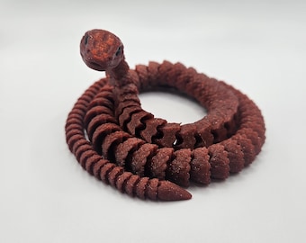 May include: A red, coiled snake figurine with a detailed head and textured scales.