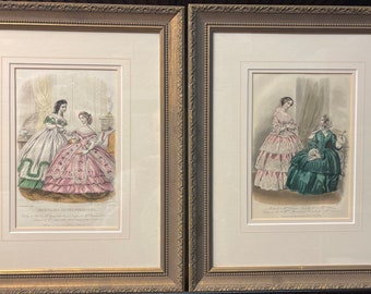 May include: Two framed prints of women in 19th-century fashion. The prints are in color and show two women in elaborate dresses. The prints are framed in gold.