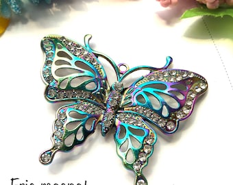 May include: A rainbow iridescent butterfly-shaped metal fridge magnet with clear rhinestones. The magnet says "Frig magnet" at the bottom.
