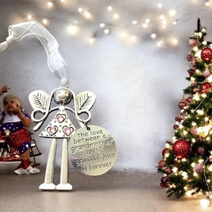May include: Silver angel ornament with pink glitter hearts and a round tag that reads "the love between a grandmother and granddaughter is forever".