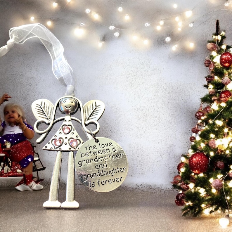 May include: Silver angel ornament with pink glitter hearts and a round tag that reads "the love between a grandmother and granddaughter is forever".
