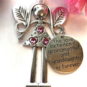 May include: Silver angel figurine with pink glitter and a heart-shaped charm that reads "the love between a grandmother and granddaughter is forever".