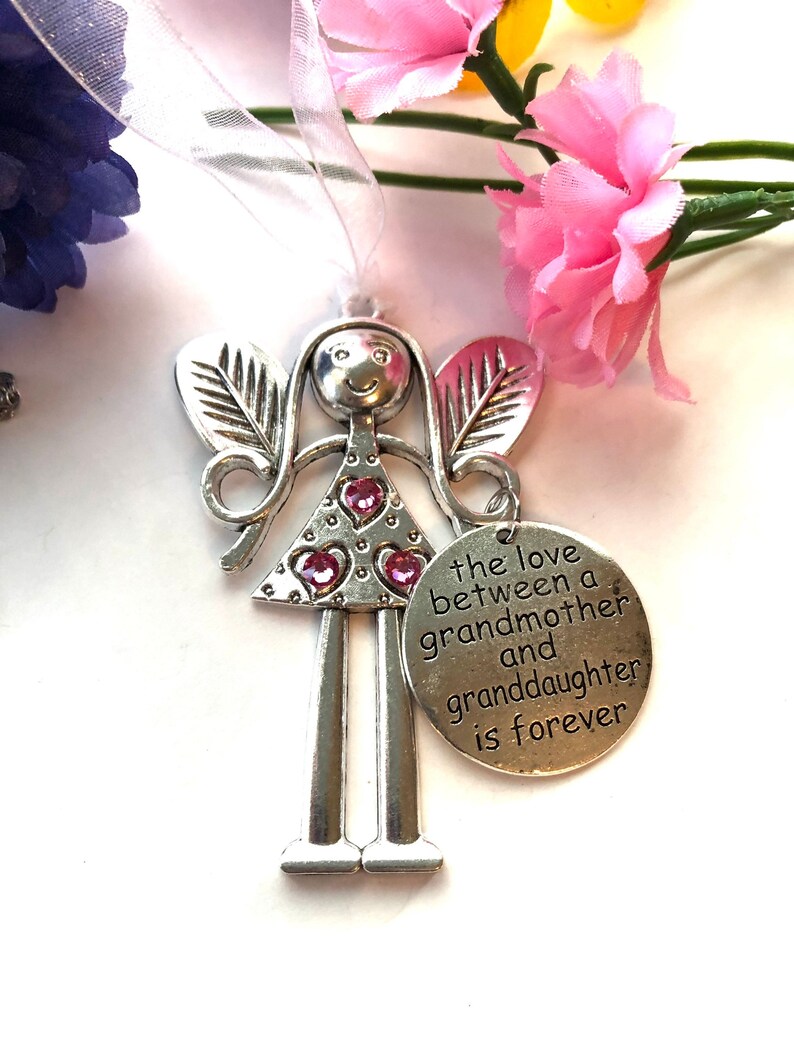 May include: Silver angel figurine with pink glitter hearts and a charm that reads "The love between a grandmother and granddaughter is forever".