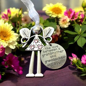 May include: Silver angel figurine with pink rhinestones and a charm that reads "The love between a grandmother and granddaughter is forever".