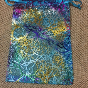 May include: A turquoise blue drawstring bag with a gold, silver, and purple iridescent leaf pattern.