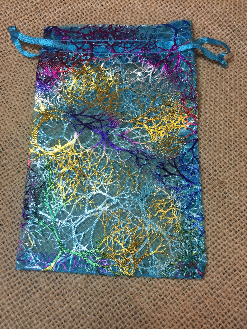 May include: A turquoise blue drawstring bag with a gold, silver, and purple iridescent leaf pattern.