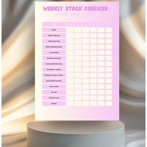May include: A pink and white weekly stock checker for nail supplies. The checklist includes items like gloves, towels, cotton pads, masks, lint-free wipes, nail files, surface disinfectant, gel remover, acrylic liquid, powder, top coats, nail forms, and nail glue.