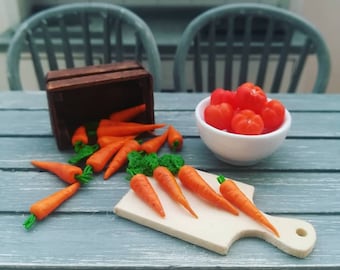 May include: A wooden crate overflowing with miniature orange carrots, some spilling onto a light blue table. A white bowl filled with red tomatoes sits next to a wooden cutting board with more carrots arranged on top.