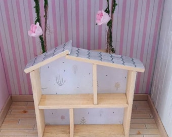May include: A miniature wooden shelf unit with a gray roof and a white background featuring a woodland pattern. The shelf has three shelves and is empty.