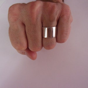 Peut inclure: Une bague en argent avec une bande large, plate et polie.