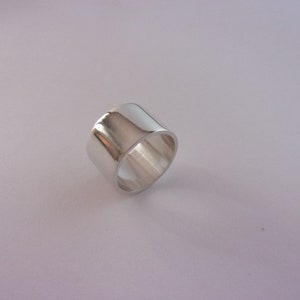Peut inclure: Une bague en argent avec une bande large et plate.