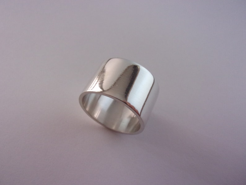 Peut inclure: Une bague large en argent avec une finition lisse et polie.