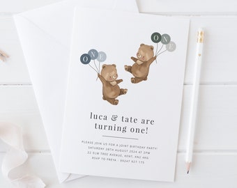 Könnte beinhalten: Eine weiße Einladungskarte mit einem braunen Umschlag. Die Karte zeigt zwei braune Bären, die Ballons mit dem Wort "ONE" halten. Der Text auf der Karte lautet "luca & tate are turning one!" und enthält Details für eine gemeinsame Geburtstagsfeier.