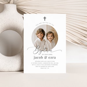 May include: A white baptism invitation with a photo of two young boys in a circle. The invitation reads "You are invited to the Baptism of our sons Jacob & Ezra" and includes the date, time, and location of the event.