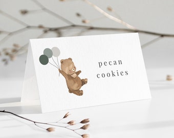 May include: A white card with a brown bear holding three green balloons. The text "pecan cookies" is printed on the card.