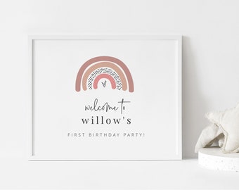 Könnte beinhalten: Ein druckbares Schild mit einem rosa, braunen und weißen Regenbogen mit schwarzen Punkten und einem kleinen rosa Herzen. Der Text lautet "Willkommen zur ersten Geburtstagsparty von Willow!"