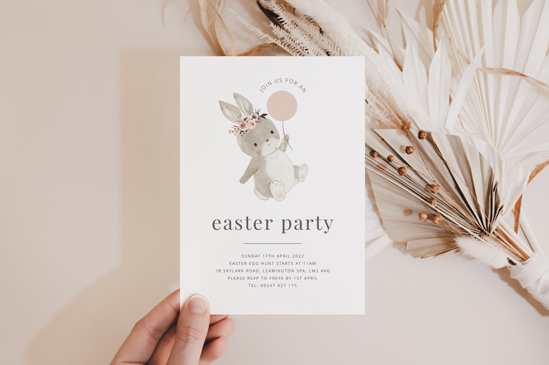 K&ouml;nnte beinhalten: Eine wei&szlig;e Einladungskarte mit einer Aquarell-Illustration eines Hasen, der einen rosa Ballon h&auml;lt. Der Text auf der Karte lautet "Join us for an easter party" und enth&auml;lt Details zur Veranstaltung, einschlie&szlig;lich Datum, Uhrzeit, Ort und RSVP-Informationen.