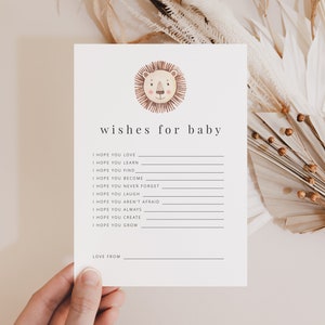 May include: A white card with a lion illustration at the top and the text "wishes for baby" below. The card has a list of wishes for a baby, such as "I hope you love", "I hope you learn", "I hope you find", "I hope you become", "I hope you never forget", "I hope you laugh", "I hope you aren't afraid", "I hope you always", "I hope you create", and "I hope you grow". The card also has a space for the sender to write "Love from".