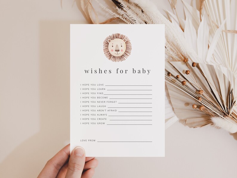 May include: A white card with a lion illustration at the top and the text "wishes for baby" below. The card has a list of wishes for a baby, such as "I hope you love", "I hope you learn", "I hope you find", "I hope you become", "I hope you never forget", "I hope you laugh", "I hope you aren't afraid", "I hope you always", "I hope you create", and "I hope you grow". The card also has a space for the sender to write "Love from".
