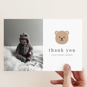May include: A thank you card with a brown bear illustration and the text "thank you" and "love from Jasper". A photo of a baby wearing a brown hooded jumpsuit is on the left side of the card.