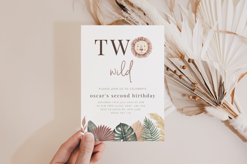 May include: A white invitation card with brown text that reads "TWO wild" and a cartoon lion face. The text below reads "Please join us to celebrate Oscar's second birthday" with details about the date, time, location, and RSVP information.