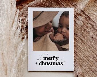 May include: A Christmas card with a photo of a woman holding a baby. The card has the text "Wishing you a merry christmas" in black text on a white background.