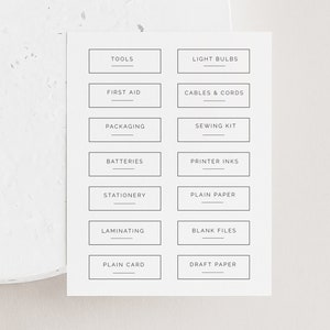 May include: A set of 12 printable labels for organizing a craft room or home office. The labels are white with black text and include categories such as tools, light bulbs, first aid, cables & cords, packaging, sewing kit, batteries, printer inks, stationery, plain paper, laminating, blank files, plain card, and draft paper.