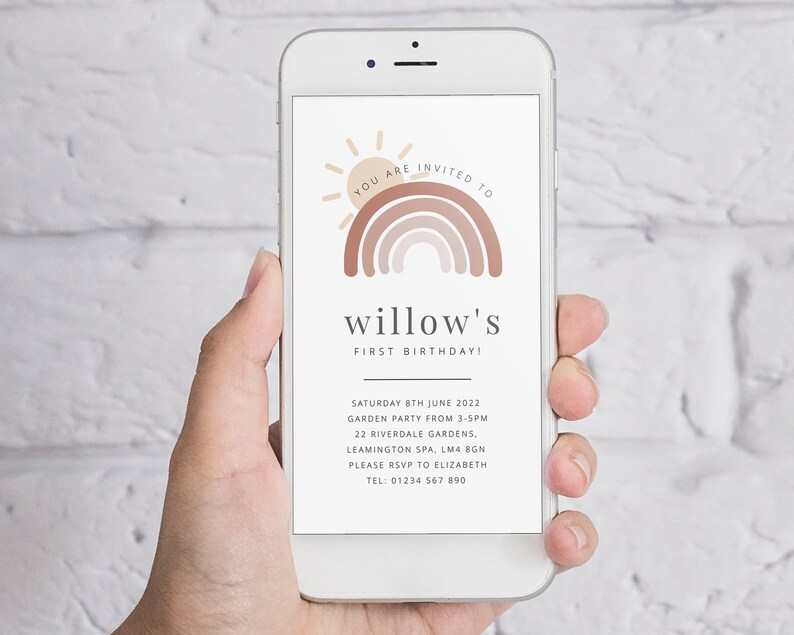 May include: A smartphone displaying a digital invitation for a first birthday party. The invitation features a rainbow with a sun and the text "YOU ARE INVITED TO willow's FIRST BIRTHDAY!"  The invitation also includes the date, time, location, and RSVP information.