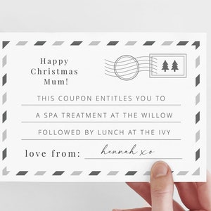 May include: A white gift certificate with a black and gray border. The text reads "Happy Christmas Mum! This coupon entitles you to a spa treatment at the Willow followed by lunch at the Ivy. Love from: hennah xo"