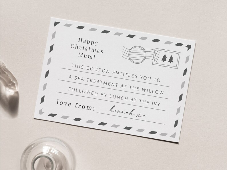 May include: A white card with a black and gray border. The card has a message that says "Happy Christmas Mum! This coupon entitles you to a spa treatment at the Willow followed by lunch at the Ivy. Love from: Hannah xo"