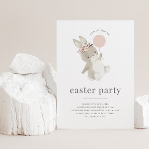K&ouml;nnte beinhalten: Ein hellgraues Kaninchen mit einem rosa Ballon und einer Blumenkrone. Das Kaninchen h&auml;lt den Ballon in seiner rechten Pfote. Der Text "JOIN US FOR AN easter party" ist unter dem Kaninchen gedruckt. Der Text "SUNDAY 17TH APRIL 2022 EASTER EGG HUNT STARTS AT 11AM 18 SKYLARK ROAD, LEAMINGTON SPA, LM2 4KG PLEASE RSVP TO FREYA BY 1ST APRIL TEL: 09247 927 175" ist unter dem Text "easter party" gedruckt.