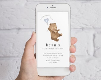May include: A digital invitation for a first birthday party with a cartoon bear holding a blue balloon with the number 1 on it. The invitation says "You're invited to beau's bear-y first birthday!" and includes the date, time, location, and RSVP information.
