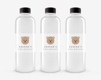 May include: Three clear plastic water bottles with brown labels. Each label features a cartoon brown bear with a white face and the text "easton's first birthday".