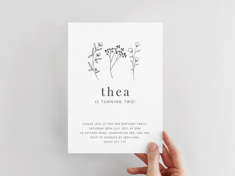 May include: A black and white birthday invitation for a child named Thea turning two. The invitation features a simple floral design and the text "thea is turning two!"  Please join us for her birthday party! Saturday 28th July 2021 at 3pm 18 Skylark Road, Leamington Spa, LM2 4KG RSVP to Georgie by 28th June 09247 927 175