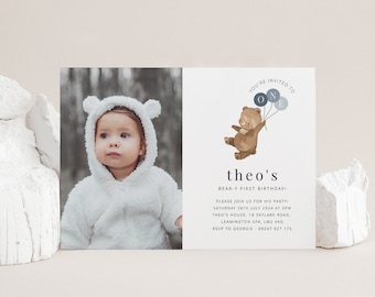 Op de afbeelding: Een verjaardagsuitnodiging met een foto van een baby in een wit, pluche outfit. De uitnodiging heeft een cartoonbeer die ballonnen vasthoudt met de letters "O" en "N" erop. De tekst op de uitnodiging luidt "You're invited to theo's Bear-y First Birthday! Please join us for his party! Saturday 28th July 2024 at 3pm Theo's House, 18 Skylark Road, Leamington Spa, LM2 4KG RSVP to Georgie 09247 927 175"