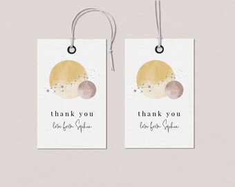 May include: Two white gift tags with a gold and pink watercolor moon and stars design. The text on the tags reads "thank you love from Sophia".
