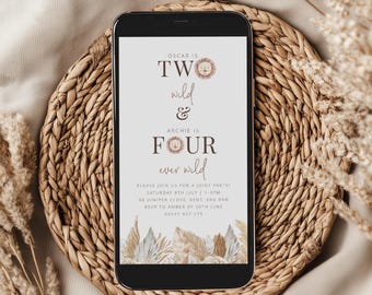 May include: A smartphone displays a joint birthday party invitation. The text reads "Two wild & Four ever wild" with lion illustrations. The invitation includes date, time, and RSVP information. The phone rests on a woven placemat with dried floral accents.
