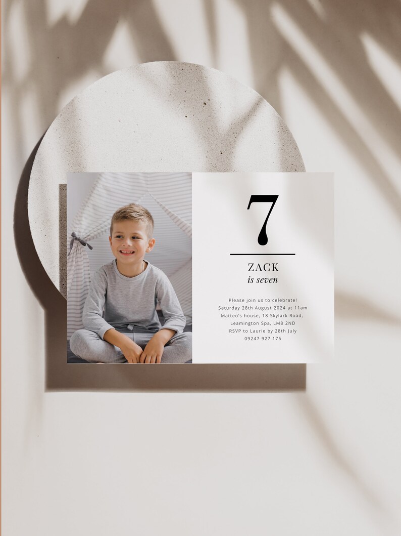 Op de afbeelding: Een verjaardagsuitnodiging voor een jongen genaamd Zack die zeven jaar wordt. De uitnodiging bevat een foto van Zack in een grijs shirt, een zwart nummer zeven en de tekst "Zack is zeven". De uitnodiging bevat de datum, tijd, locatie en RSVP-informatie.