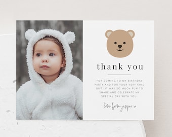 Pode incluir: Um cartão de agradecimento com uma foto de um bebê usando uma roupa branca com capuz. O cartão tem uma ilustração de um urso marrom e o texto "obrigado" e "com amor de jasper xo".