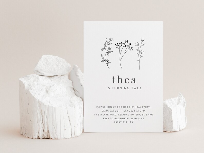 May include: A black and white birthday invitation for a child named Thea turning two. The invitation features a simple floral design and the text "thea is turning two!"  Please join us for her birthday party! Saturday 28th July 2021 at 3pm 18 Skylark Road, Leamington Spa, LM2 4KG RSVP to Georgie by 28th June 09247 927 175