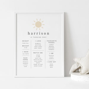 Peut inclure: Une affiche imprimable avec un graphique de soleil et le texte "harrison a un an !" L'affiche liste des informations sur l'enfant, y compris sa taille, son poids, ses aliments pr&eacute;f&eacute;r&eacute;s et les choses qu'il sait faire.