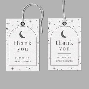 Könnte beinhalten: Zwei weiße Dankeschön-Etiketten mit einem Design aus Halbmond und Sternen. Der Text auf den Etiketten lautet "Danke" und "Baby Shower von Elizabeth".